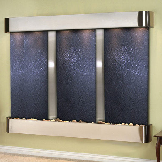 Wall-mounted water feature with blue panels and metallic accents on a green wall.